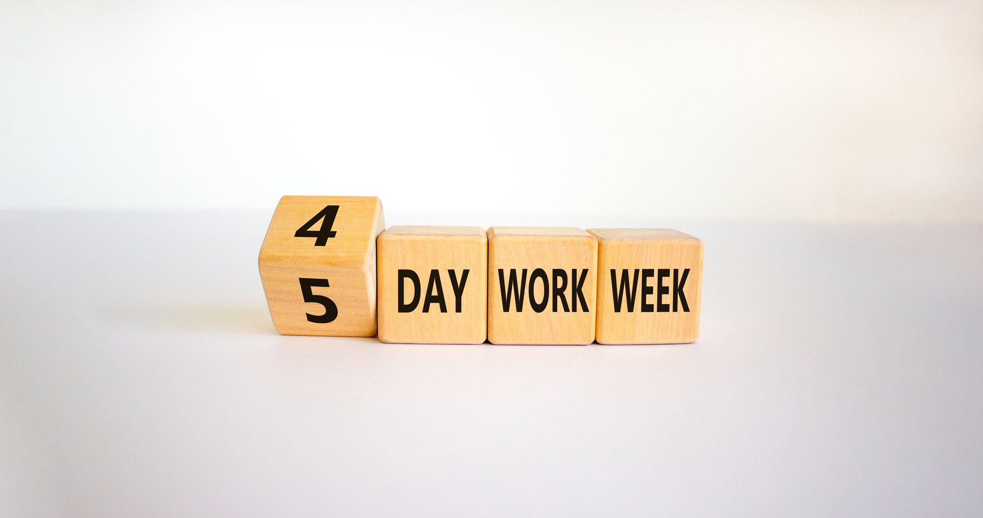 semana laboral de cuatro días Dados de madera sobre fondo gris